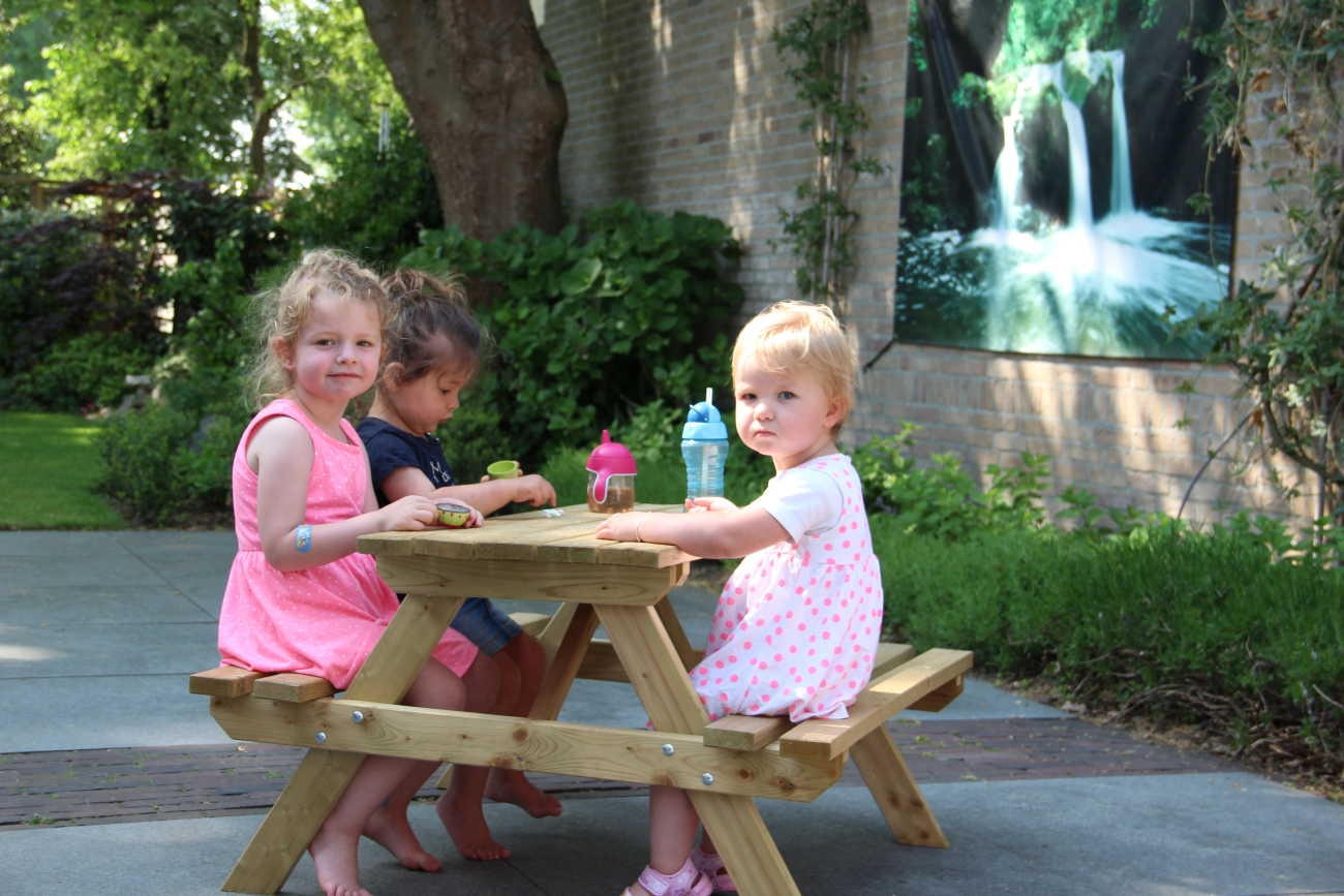 Kinderen aan het eten in de tuin